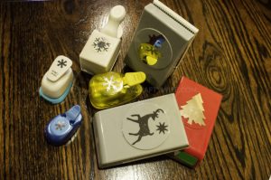 Use paper crafts to create a winter wonderland picture display for your home. Use a snowman hole punch and other paper craft items to create the scene.