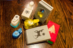Use paper crafts to create a winter wonderland picture display for your home. Use a snowman hole punch and other paper craft items to create the scene.