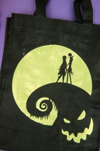 Halloween Tote Bag - As a kid I always wanted my own personalized Halloween tote bag to carry my candy around in, but since that'll never happen I can at least do it for my kids! This easy Nightmare Before Halloween tote bag can be made with a Silhouette or Cricut machine. It's so spooky, even the parents will want one of their own.