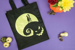Halloween Tote Bag - As a kid I always wanted my own personalized Halloween tote bag to carry my candy around in, but since that'll never happen I can at least do it for my kids! This easy Nightmare Before Halloween tote bag can be made with a Silhouette or Cricut machine. It's so spooky, even the parents will want one of their own.