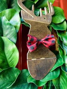 Make the easiest holiday wreath to last through Christmas and beyond! All it takes is a little bit of greenery, wood, and the perfect buffalo plaid ribbon to give your front door a little holiday style.