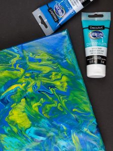 Acrylic Pour Canvas - This is one messy DIY but it is really fun to make too! You can get creative with color and design and no two art projects will be the same! It's the perfect art piece for your home that YOU made all on your own!