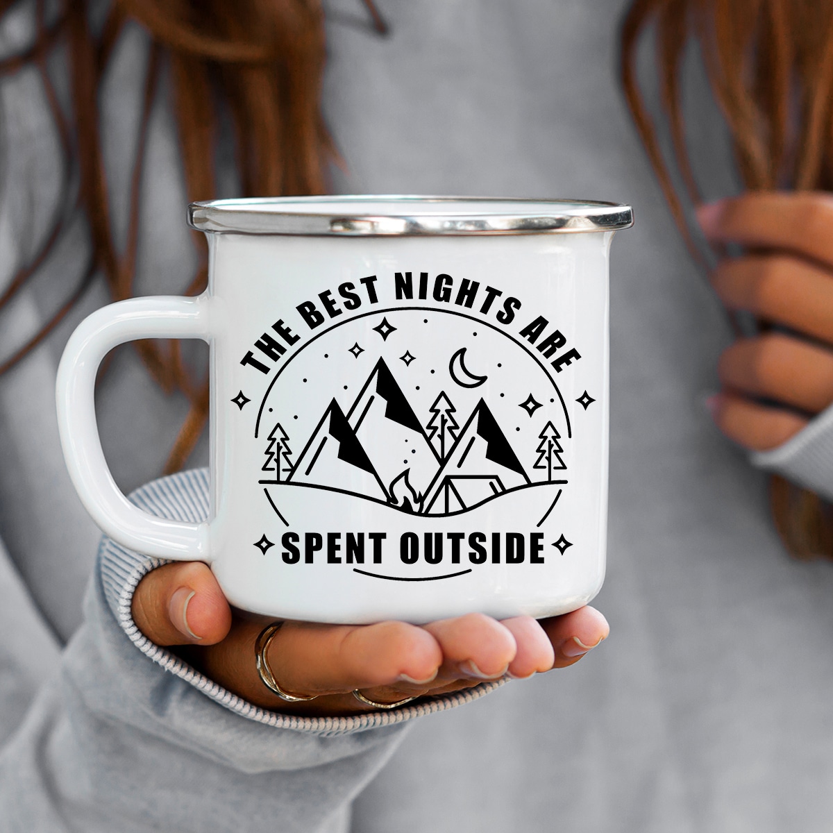 Circle with the words the best nights are spent outside around the outside of it. And on the inside there are mountains, trees, a tent and a fire